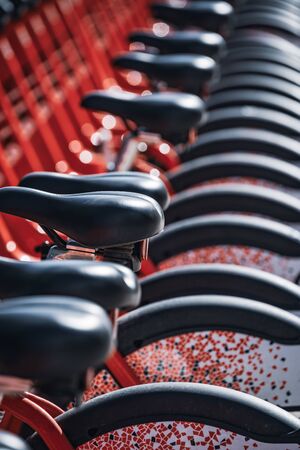 Abstract detail of a row of modern rental bicycles parked on a city streetの写真素材