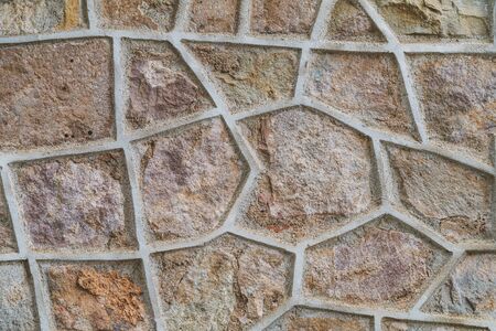 Background of an old natural stone wall with concrete divider shapesの写真素材