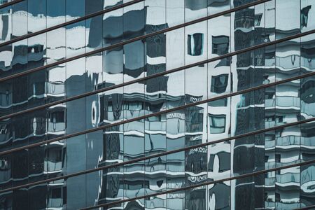 Urban residential building reflected in a blue glass facadeの写真素材