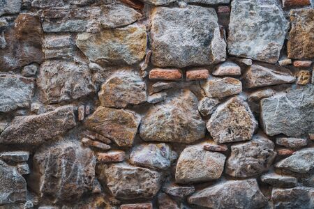 Texture of an old wall made of natural stones and red bricksの写真素材