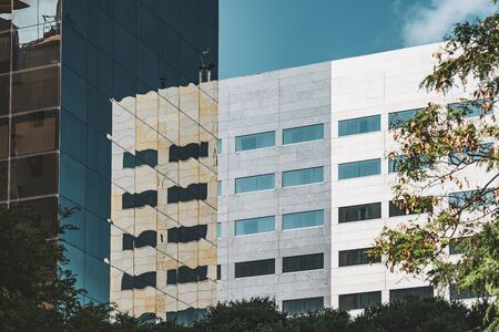 Reflections on the glass facade of an office buildingの写真素材