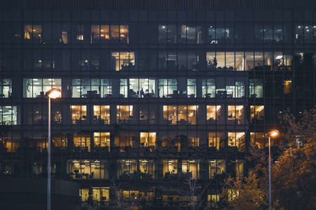 Illuminated windows of an office building at nightの写真素材