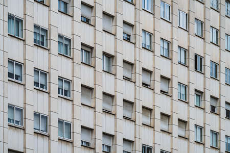 Rows of windows with roller shutters on the facade of an urban building