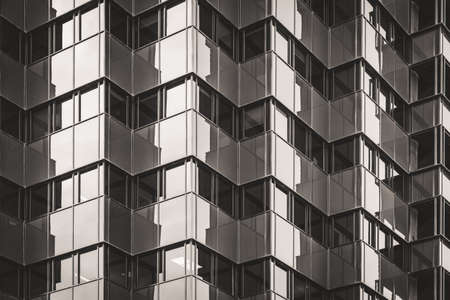 Geometric glazed facade of an office building in black and whiteの写真素材