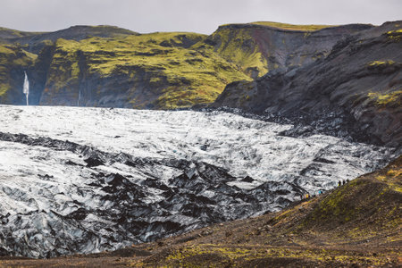 Glacier meeting green covered hills in Icelandの写真素材