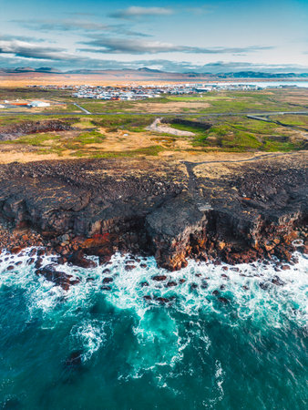 Fishing town in Iceland, waves crushing on the shore, sunny day in autumn