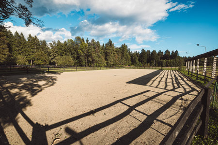 Soft sand on the ground of fenced riding ring for horseback riding and training