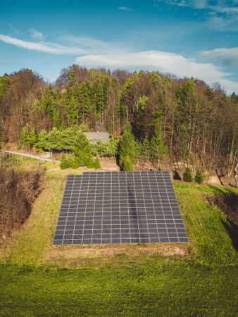 Vertical view of solar panels stacked on a sunny side of the hill in the country sideの写真素材