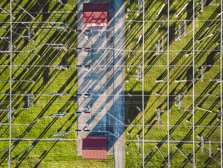 Directly above electrical substation with electrical wires spread around the power stationの写真素材