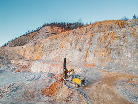 Yellow excavator digging rocks at the quarry, doing all the hard workの写真素材