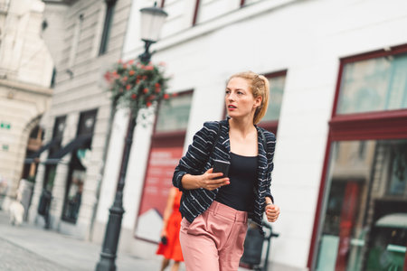 Blonde woman running errands in the city on the way to a meeting