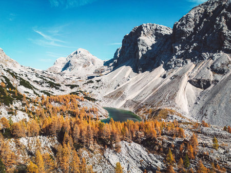 Scree slopes under mountain tops and a small lake in the valley of Triglav national parkの写真素材