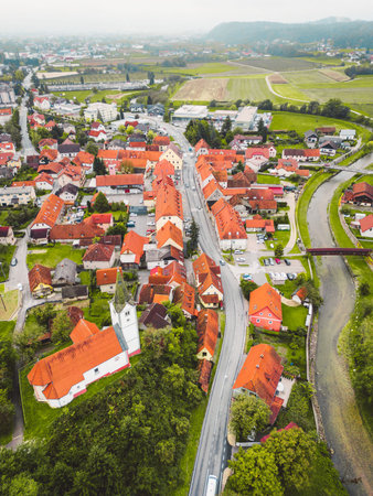 Vertical photo of an old town and a river trough the town on a cloudy autumn dayの写真素材