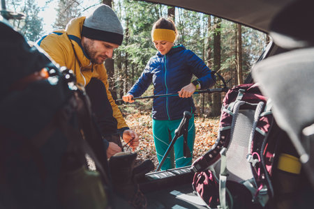 Young couple going for a hike, packing theri thinks in the car trunkの写真素材