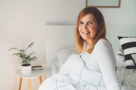 Smiling woman portrait, getting out of bed in the morning, feeling greatの写真素材