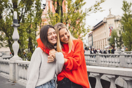 Sister hugging while walking on the city streets, having a day off to spend togetherの写真素材