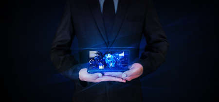 Modern cryptocurrency glowing holographic screen with bitcoin backdrop on mobile screen. Man holding mobile with glowing screen of cryptocurrencyの写真素材