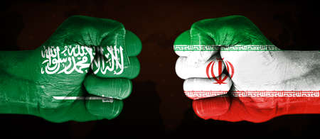 Kingdom Saudi Arabia and Iran Flag Painted on a Fists Pointing Towards Each Other. Country Conflicts Concept media backgroundの写真素材