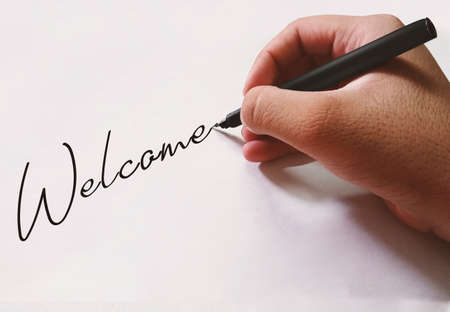 Welcome Message Writing with Hand on a White Black Paper. Modern welcome message space backdropの写真素材