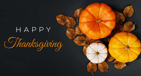 Happy Thanksgiving card with pumpkins on black background. Top view, flat lay.の写真素材