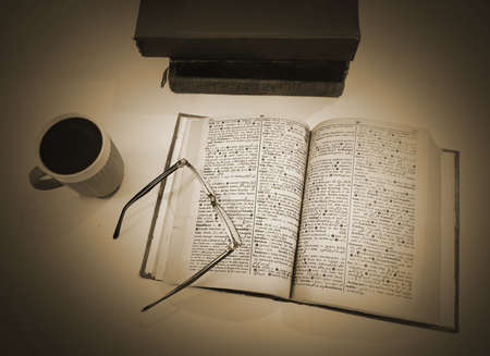 An old book with glasses and a cup of coffee. Toned.の写真素材