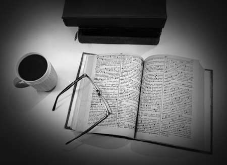 A book and a cup of coffee on a black and white backgroundの写真素材
