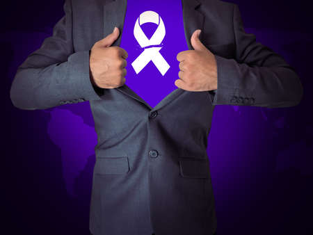 Businessman showing symbol of breast cancer awareness on purple background, closeupの写真素材