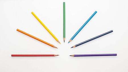 Color pencils rainbow colors in the form of a fan on a white background top view copy space