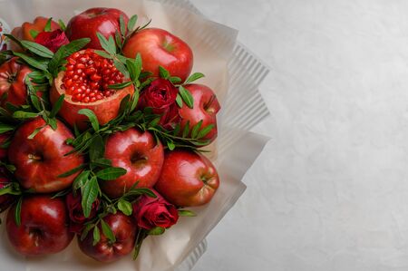 Fruit bouquet of apples, pomegranate and roses on a whiteの写真素材