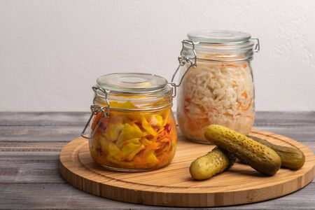 Homemade pickled cabbage in jars and pickles on a wooden board. Close up. Copy space. Horizontal orientationの写真素材