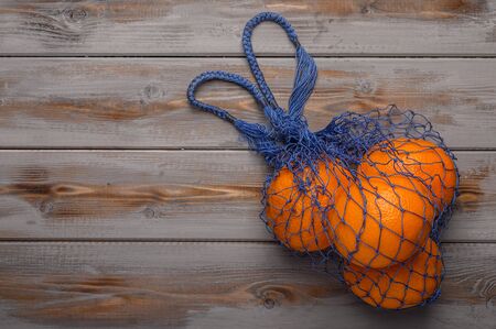 Oranges in a mesh string bag made of natural material. Environmental protectionの写真素材
