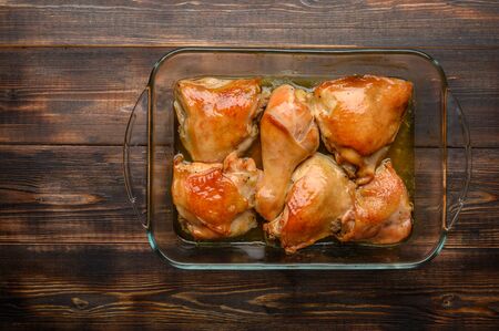 Homemade baked chicken thighs with soy sauce and spices in a glass tray. Copy space. Top viewの写真素材