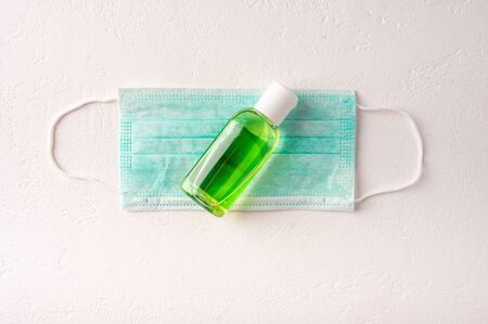 Protective medicine face mask, antiseptic gel on light background. Top view. Copy spaceの写真素材