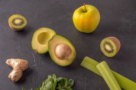 Ginger, avocado, apple, kiwi, celery on a dark background. Ingredients for smoothies. Healthy food