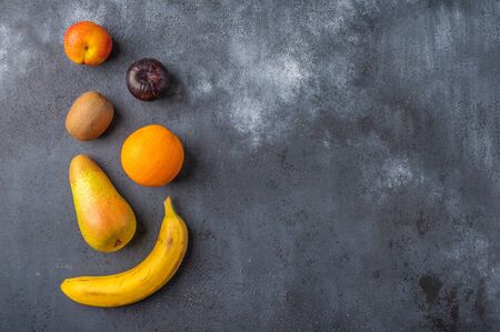 Ingredients for fruit salad on a dark wooden surface. Top view. Copy spaceの写真素材