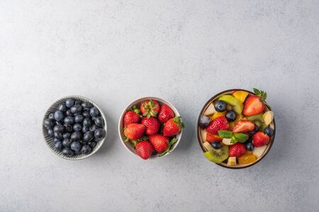 Fresh fruit salad with different ingredients on light wooden background. Healthy diet. Copy space for text. Top viewの写真素材