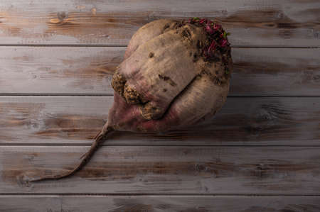 Big ugly organic ripe beetroot on a wooden background, close up, top viewの写真素材