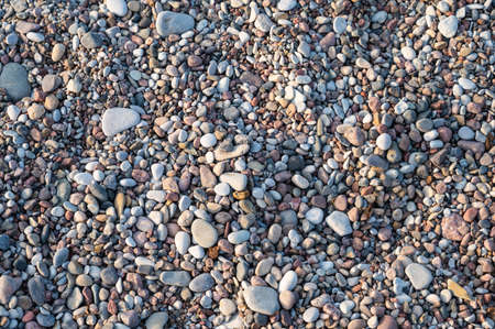 Background of multi-colored pebbles on the sea beach, close up, horizontal orientation