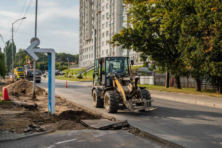 RUSSIA, KALININGRAD - SEPTEMBER 07, 2020: Loader machine drives down the street, next to the...