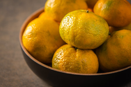 Tangerines or mandarines in bamboo bowl close up selective focusの写真素材