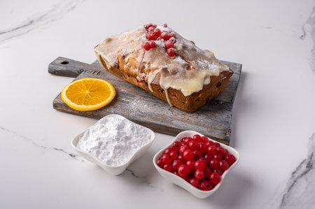Homemade cupcake with cranberries and icing sugar and the ingredients on wooden cutting board on light background, copy spaceの写真素材