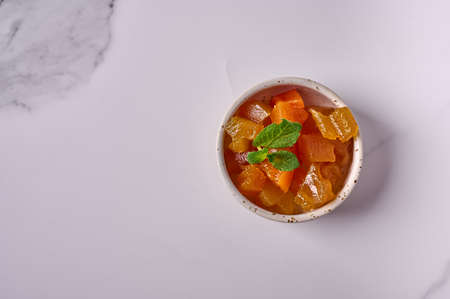 Melon jam with mint in a small bowl on a light background. Top view. Copy spaceの写真素材