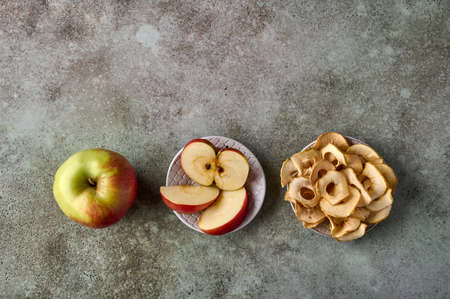 Apples chips, slices and apple fruit on rustic wooden background. Flat lay, copy spaceの写真素材