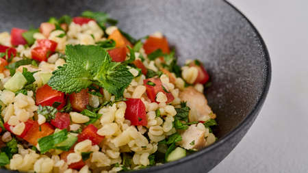 Macro Middle Eastern traditional salad tabbouleh made of bulgur or couscous. Selective focusの写真素材