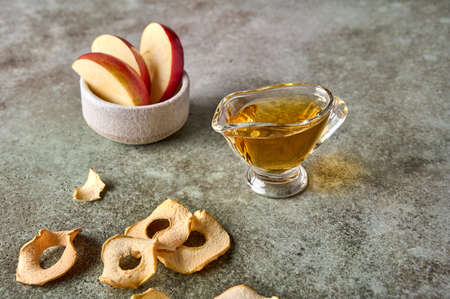 Apples slices in bowl, chips and juice on rustic wooden background. Close up. Selective focusの写真素材