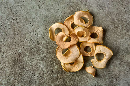 Dehydrated apples chips on textured wooden background. Top view. Copy spaceの写真素材