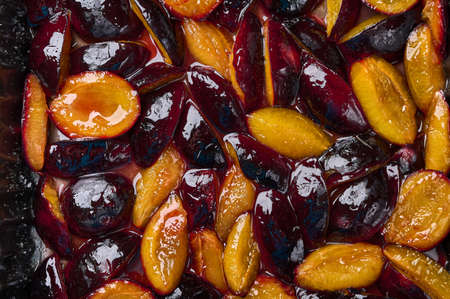 Caramelized in sugar syrup pieces of plums, food background. Close up, flat layの写真素材