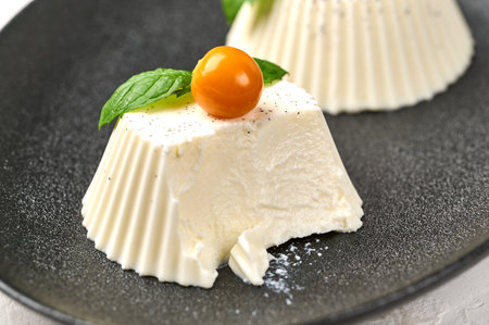 Macro uncut homemade panna cotta with natural vanilla pod, physalis or winter cherry and mint, selective focusの写真素材