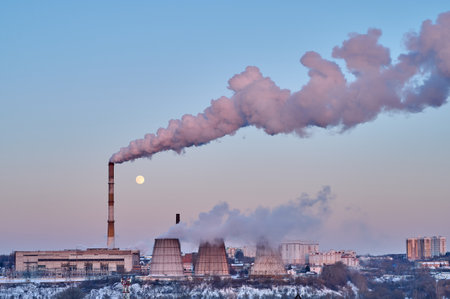 View of the thermal power station on sunset and moon in the sky. White thick smoke coming from the pipesの写真素材