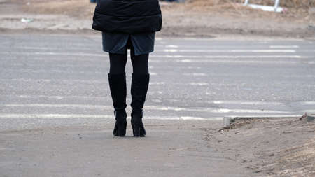 Legs of a girl standing on the sidewalkの写真素材